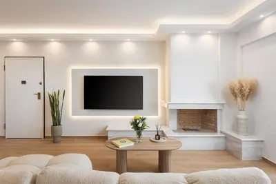 a living room with a couch and a tv at Majestique South Riviera Residence in Athens