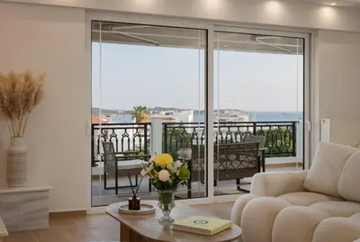 a living room with a couch and a balcony at Majestique South Riviera Residence in Athens