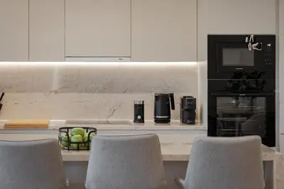 a kitchen with a counter with chairs and a microwave at Majestique South Riviera Residence in Athens