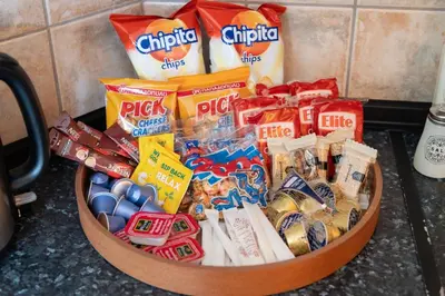 a basket of chips and other snacks in a counter at Luxury, entire, 2-10 person apartment in ilioupoli in Athens