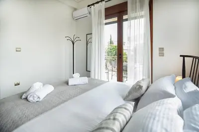 two beds in a room with a large window at Luxury, entire, 2-10 person apartment in ilioupoli in Athens