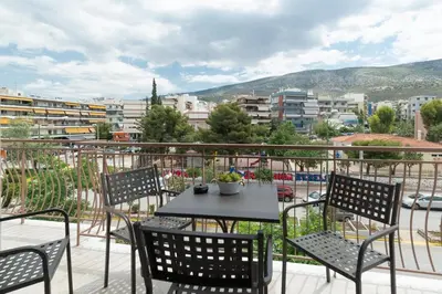 a table and chairs on a balcony with a view of a city at Luxury, entire, 2-10 person apartment in ilioupoli in Athens
