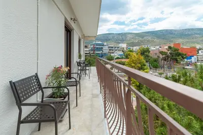 a balcony with chairs and a view of a city at Luxury, entire, 2-10 person apartment in ilioupoli in Athens