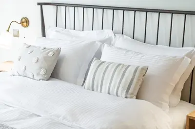a pile of white pillows on a bed at Luxury, entire, 2-10 person apartment in ilioupoli in Athens
