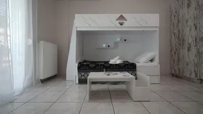 a white room with a bed and a table at Maria's Ethereal Place in Athens
