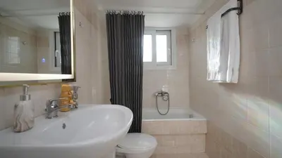 a bathroom with a sink and a toilet and a window at Maria's Ethereal Place in Athens