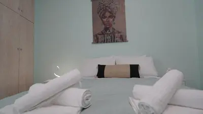 a bedroom with a white bed with towels on it at Maria's Ethereal Place in Athens