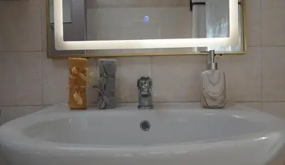 a bathroom sink with a mirror and a toothbrush at Maria's Ethereal Place in Athens