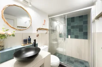 a bathroom with a glass shower and a black sink at Comfort Athens Apartment near Metro Station in Athens