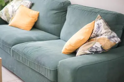 a blue couch with two pillows on it at Comfort Athens Apartment near Metro Station in Athens