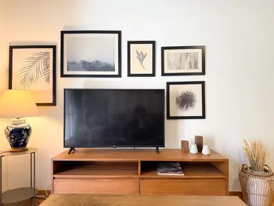 a living room with a flat screen tv and framed pictures at Achaiou Apartment Kolonaki in Athens