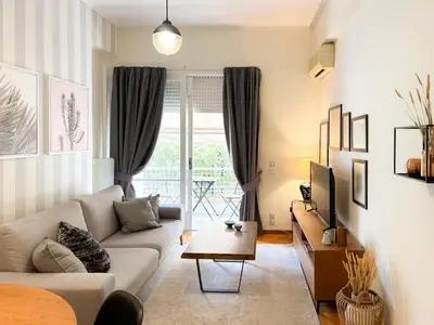 a living room with a couch and a tv at Achaiou Apartment Kolonaki in Athens