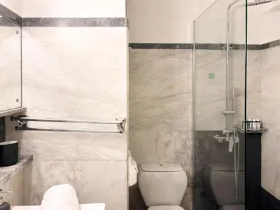 a bathroom with a toilet and a glass shower at Achaiou Apartment Kolonaki in Athens