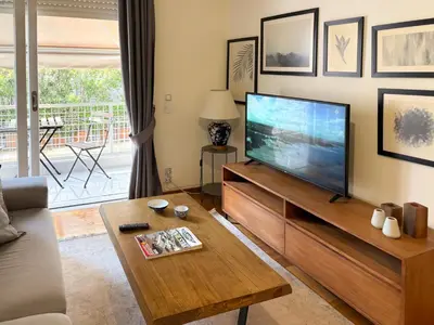 a living room with a large flat screen tv at Achaiou Apartment Kolonaki in Athens