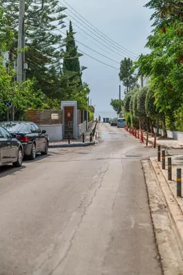 an empty street with cars parked on the side of the road at Pure Azure in Athens