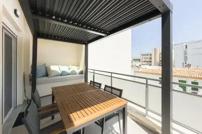 a balcony with a wooden table and a couch at City Beat Athens Studio in Athens