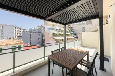 a balcony with a wooden table and two chairs at City Beat Athens Studio in Athens