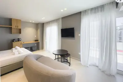 a bedroom with a bed and a couch and a chair at City Beat Athens Studio in Athens