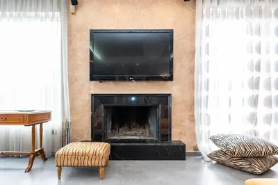 a living room with a fireplace with a flat screen tv on the wall at Vasso Villa in Vravrona
