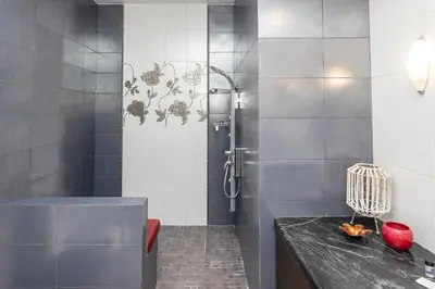 a bathroom with a shower with a black counter at Vasso Villa in Vravrona