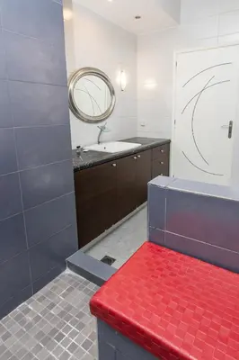 a bathroom with a red bench in front of a sink at Vasso Villa in Vravrona