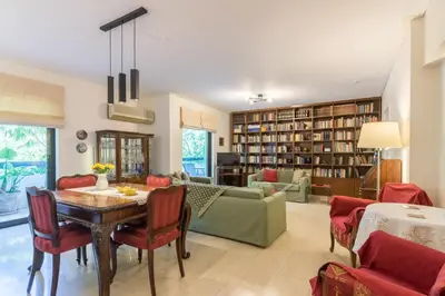 a living room with a table and chairs and a library at Seaside Apartment in Palaio Faliro in Athens