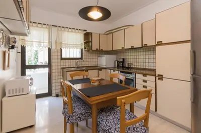 a kitchen with a table and chairs and a refrigerator at Seaside Apartment in Palaio Faliro in Athens