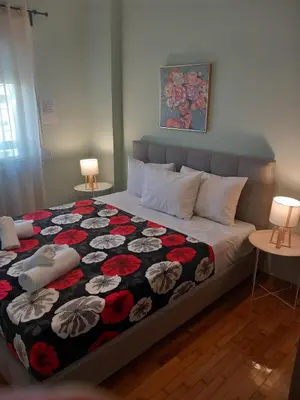 a bedroom with a bed with a floral quilt at Αpt in Gazi in front of metro in Athens