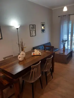 a living room with a wooden table and chairs at Αpt in Gazi in front of metro in Athens