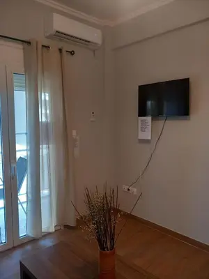 a living room with a flat screen tv on the wall at Αpt in Gazi in front of metro in Athens
