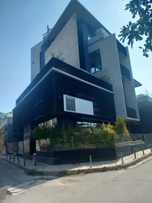 a large black building on the side of a street at Αpt in Gazi in front of metro in Athens