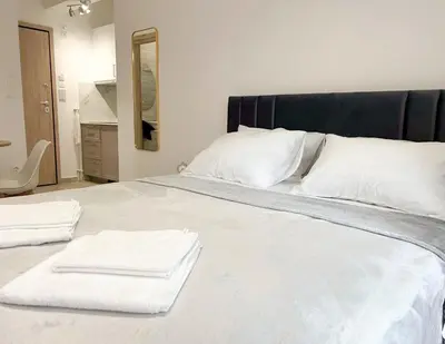 a large white bed with two towels on it at Ridis Studio Athens in Athens