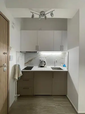 a kitchen with white cabinets and a sink at Ridis Studio Athens in Athens