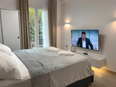 a bedroom with a bed with a flat screen tv on the wall at Ridis Studio Athens in Athens