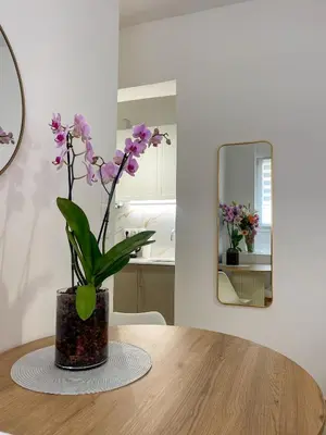 a vase with purple flowers sitting on a wooden table at Ridis Studio Athens in Athens