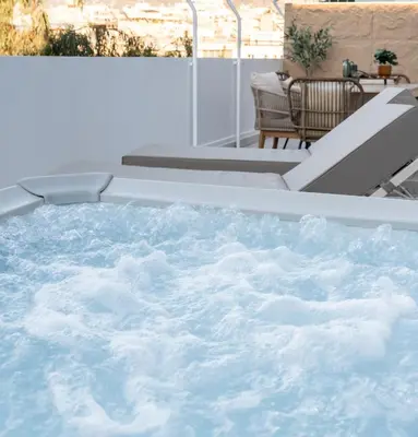 a jacuzzi tub on a balcony with a table at Acropolis Atelier, Plunge Pool Apartments in Athens