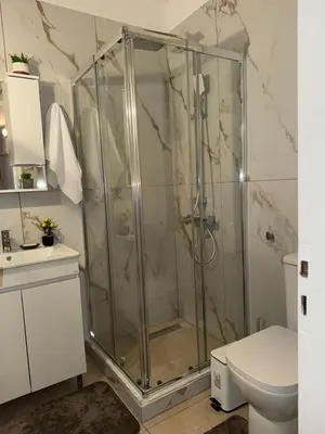 a glass shower in a bathroom with a toilet at Casa Esmeralda Faliro in Athens
