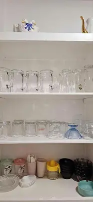 a white shelf filled with glasses and other items at Casa Esmeralda Faliro in Athens
