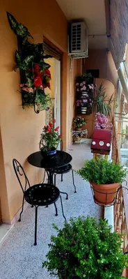a patio with a table and chairs and potted plants at Casa Esmeralda Faliro in Athens