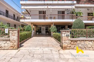a large building with a stone wall in front of it at Athens Riviera APT, Near Seaside with Private Parking in Athens