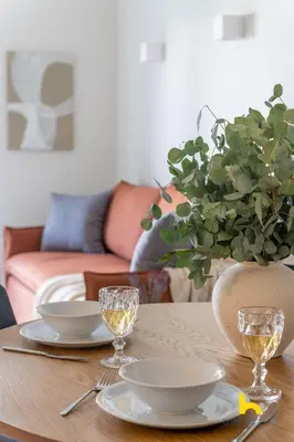 a table with plates and glasses and a vase with a plant at Athens Riviera APT, Near Seaside with Private Parking in Athens
