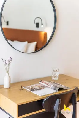 a mirror on a wall above a wooden table with a desk sidx sidx at Athens Riviera APT, Near Seaside with Private Parking in Athens