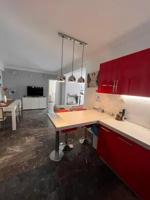 a kitchen with red cabinets and a table in it at Apartment Glyfada Athens at One o One Seven, bright and spacious apartment located on the first floor with no elevator in Athens
