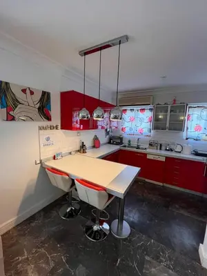 a kitchen with red cabinets and a wooden counter top at Apartment Glyfada Athens at One o One Seven, bright and spacious apartment located on the first floor with no elevator in Athens