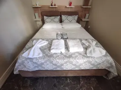 a bed with two towels and shoes on it at Apartment Glyfada Athens at One o One Seven, bright and spacious apartment located on the first floor with no elevator in Athens