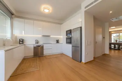 a kitchen with white cabinets and a stainless steel refrigerator at Anlijors Premium Residency in Kalívia Thorikoú