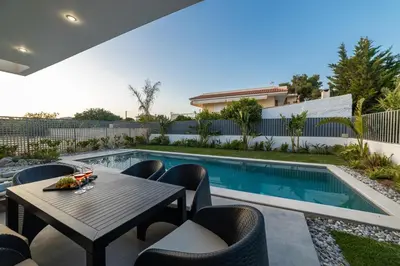 a patio with a table and chairs next to a swimming pool at Anlijors Premium Residency in Kalívia Thorikoú