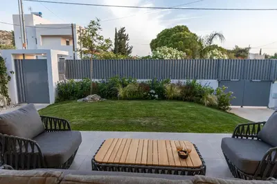 a patio with two chairs and a wooden table at Anlijors Premium Residency in Kalívia Thorikoú