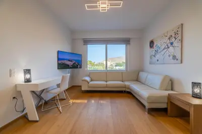 a living room with a couch and a table and a desk at Anlijors Premium Residency in Kalívia Thorikoú