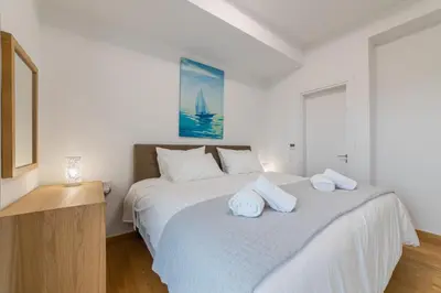 a white bedroom with a bed with towels on it at Anlijors Premium Residency in Kalívia Thorikoú